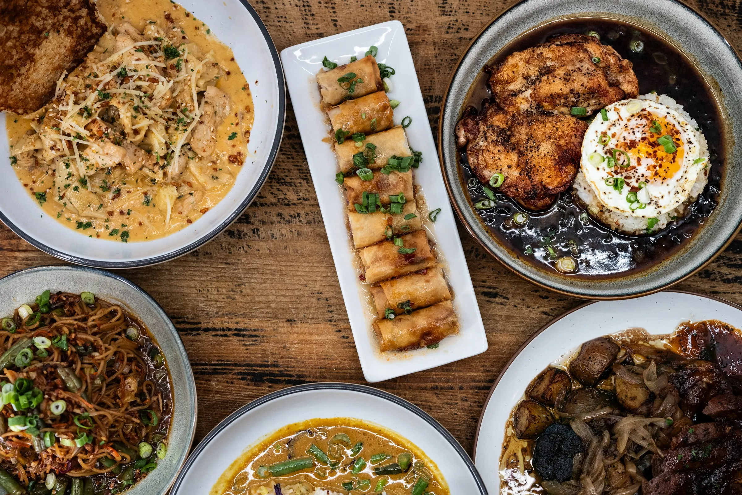 Overhead spread of plated dishes at 27 Aluna.